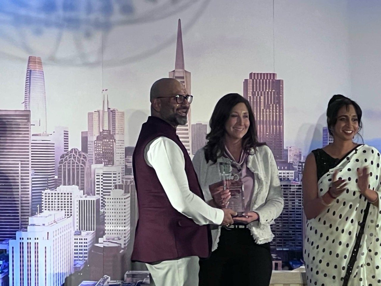 BART Board President Melissa Hernandez presents Gaurav Rastogi with the Swami Vivekananda Award for Advancing Pluralism on stage at the Hindu American Foundation Bay Area Gala